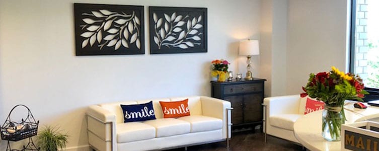 lobby at dentist office with white couch, colorful pillows